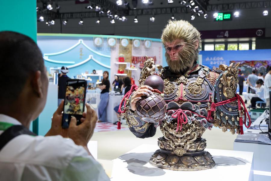 Seorang pengunjung mengambil foto bust ‘Black Myth: Wukong’ semasa berlangsungnya Pameran Industri Kebudayaan Antarabangsa (Shenzhen) China di Provinsi Guandong, selatan China pada 23 Mei 2025. (Xinhua/Liang Xu)