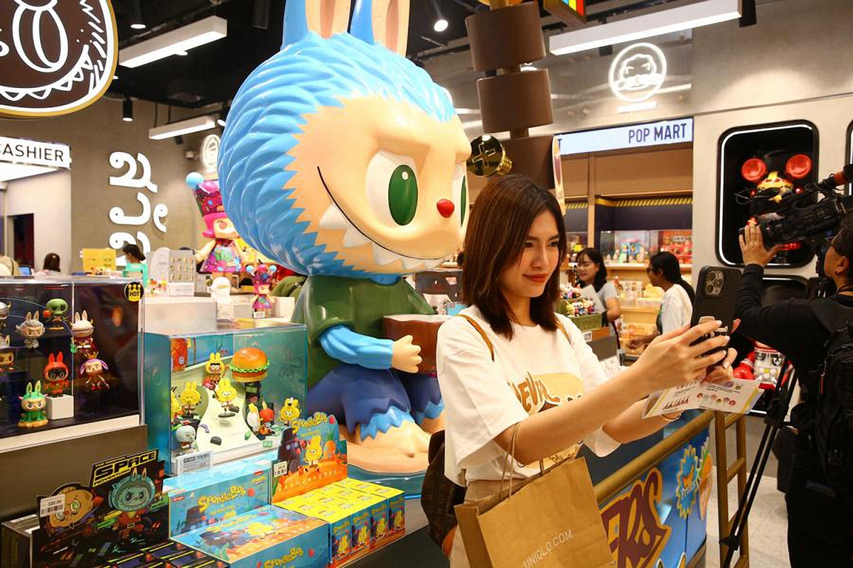 Seorang pelanggan mengambil swafoto dengan sebuah patung di kedai Pop Mart di Bangkok. (Foto oleh Xinhua)