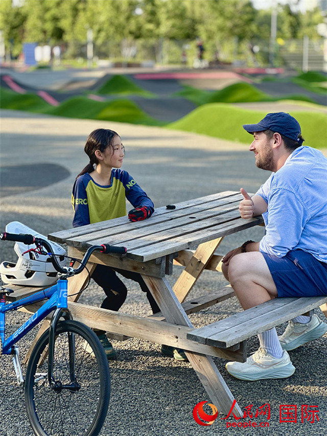 Michael Kurtagh, pakar asing People’s Daily Online berbual-bual dengan Sun Xiaoxiao, 8 tahun, yang juga juara kumpulan perempuan Liga Pump Track China 2024 (Shenyang) di Taman Trek Pam Antarabangsa Shenyang. (People’s Daily Online/Qiu Yuzhe)