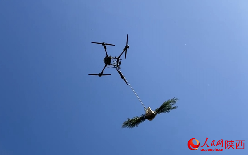 Sebuah dron membawa benih ke sebuah tapak penghutanan di kaunti Yichuan, bandar Yan’an, Provinsi Shaanxi di barat laut China. (People’s Daily Online/Bai Ge)