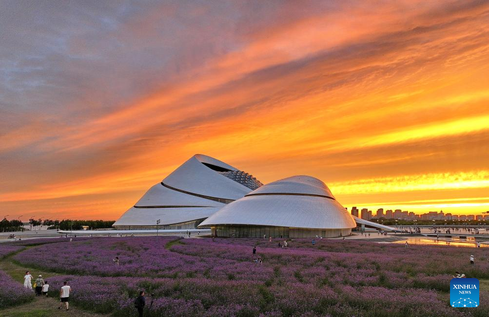 Foto dron ini memperlihatkan orang ramai berjalan-jalan di sekitar dan mengambil foto matahari tenggelam di luar Harbin Grand Theater, di Harbin, Provinsi Heilongjiang, timur laut China pada 20 Julai 2025. (Xinhua/Yang Wei)