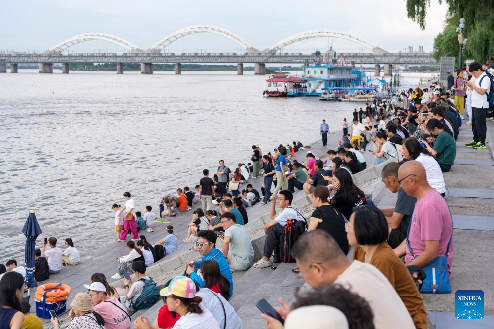Foto ini menunjukkan orang ramai sedang duduk di tangga, sambil menikmati udara dingin di tepi Sungai Songhua, di Harbin, Provinsi Heilongjiang, timur laut China pada 1 Ogos 2025. (Xinhua/Xie Jianfei)