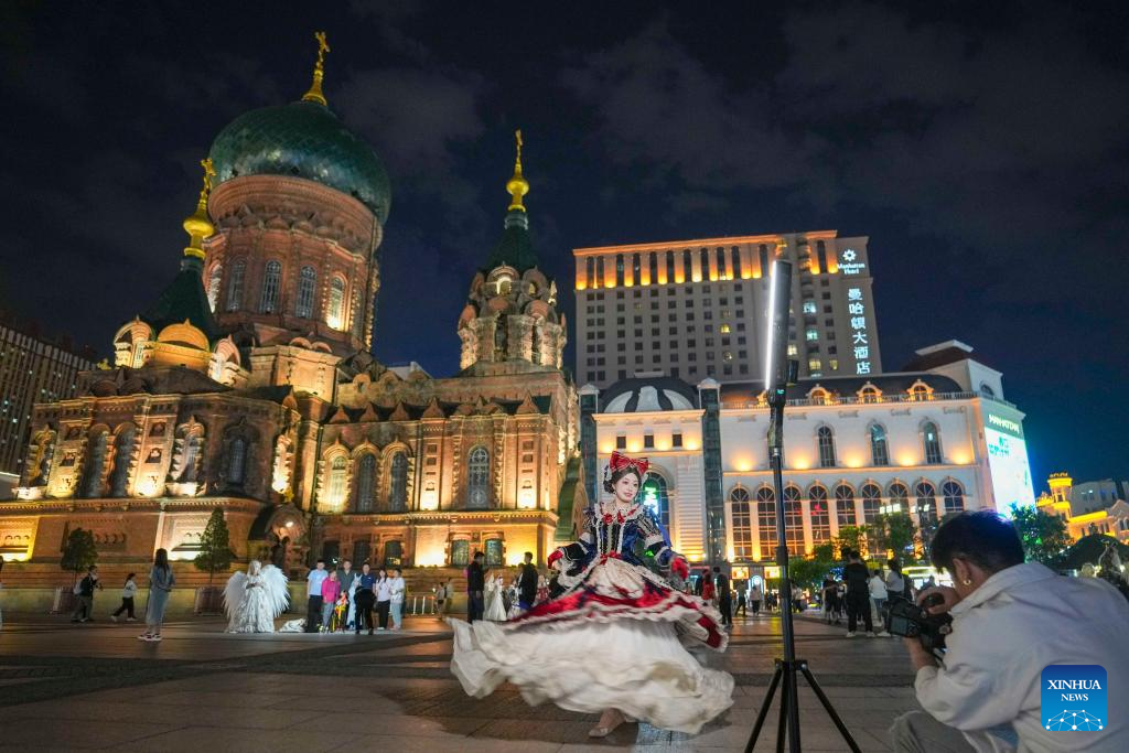 15. Pelancong yang penuh bergaya mengambil gambar dengan berlatarbelakangkan Gereja Besar St. Sophia di Harbin, Provinsi Heilongjiang, timur laut China pada 8 Jun 2025. (Xinhua/Wang Jianwei)
