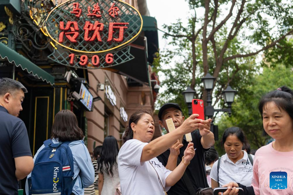 16. Para pelancong mengamil swafoto dengan ais krim Modern di Central Street di Harbin, Provinsi Heilongjiang, timur laut China pada 1 Ogos 2025. (Xinhua/Xie Jiangfei)