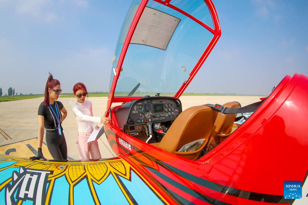 Seorang tenaga pengajar (kanan) sedang memeriksa pesawat bersama-sama dengan seorang pelatih sebelum terbang di taman industri penerbangan am di Laixi, Qingdao, Provinsi Shandong, timur China pada 24 Ogos 2025. (Xinhua/Zhang Jingang)