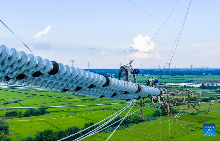 Para pekerja giat menjalankan kerja-kerja cantuman konduktor untuk projek penghantaran tenaga terus UHV ±800 kV Gansu-Zhejiang di kaunti Nanling, Wuhu, Provinsi Anhui pada 16 September 2025. (Xinhua/Zheng Xianlie)