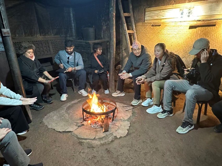 Wartawan dari kawasan Asia Pasifik duduk mengelilingi unggun api di rumah lama Jimu Ziluo, seorang penduduk kampung di Sanhe, kaunti Zhaojue, Kawasan Autonomi Yi Liangshan, Provinsi Sichuan di barat daya China. (Foto oleh Zhang Yuxin)