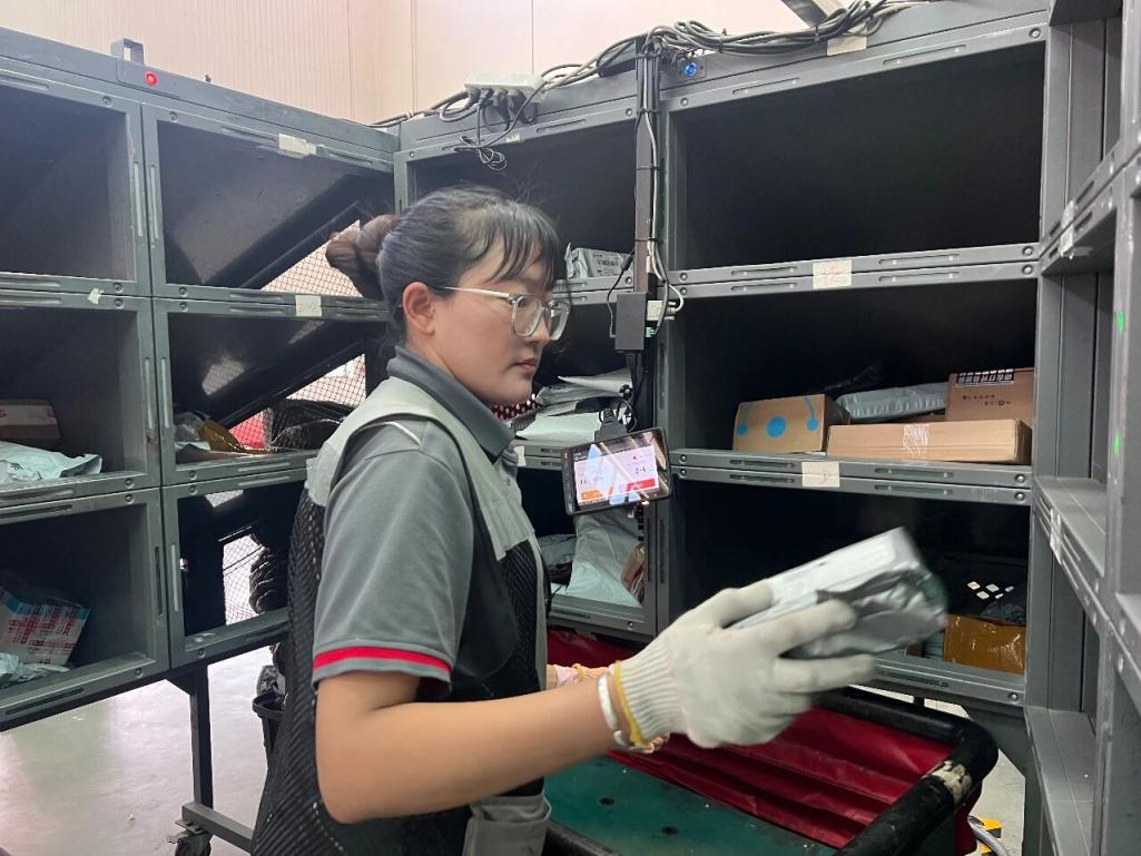 Seorang pekerja mengisih bungkusan dengan kabin pintar di sebuah pusat pemindahan SF Express di Lhasa, Wilayah Xizang di barat daya China.