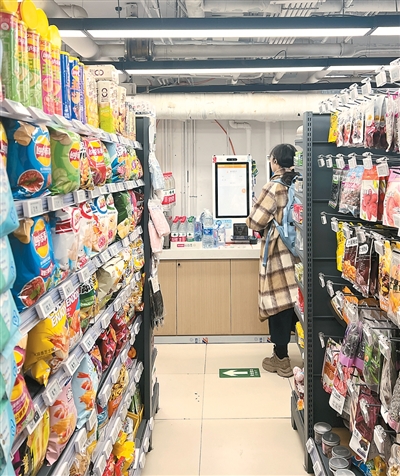 Seorang pembeli di dalam kedai mudah beli automatik di kampus sebuah universiti di Beijing. (Foto oleh Zhu Yingxi)