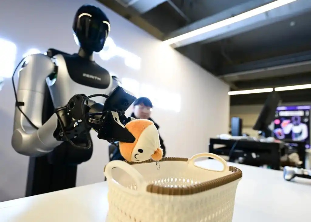 Seorang anggota petugas melatih sebuah robot untuk mengambil satu permainan bagi tujuan pengumpulan data. (Xinhua/Zhou Mu)