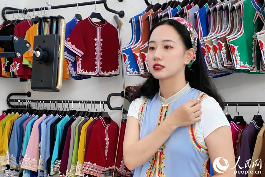 Seorang wanita muda Hui'an menerangkan konsep reka bentuk di sebalik pakaian wanita Hui'an semasa sesi penstriman langsung. (People's Daily Online/Yang Haoyu)