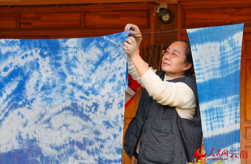 Huang Lin mengeringkan tekstil ikat celup di bengkelnya di kampung Nakeli, kaunti autonomi Hani dan Yi Ning’er, provinsi Yunnan, barat daya China. (People's Daily Online/Hu Zunhui)
