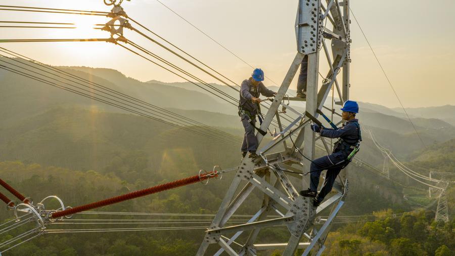 Foto dron menunjukkan juruteknik sedang memeriksa satu seksyen talian penghantaran kuasa dalam projek ketersambungan 500-kV China-Laos di kawasan autonomi Dai Xishuangbanna, provinsi Yunnan, barat daya China, 14 April 2026. (Xinhua)