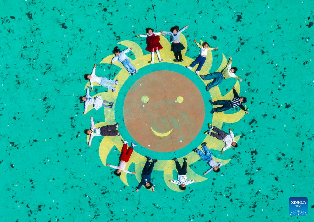 Foto dron pada 8 Mei 2026 menunjukkan sekumpulan kanak-kanak membentuk corak muka senyum di sebuah tadika di daerah Hailing, bandar Taizhou, provinsi Jiangsu, timur China. (Foto oleh Tang Dehong/Xinhua)