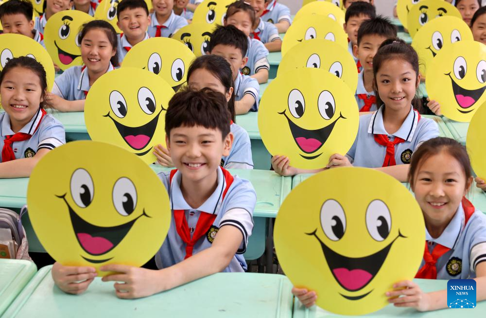 Para pelajar memegang ikon muka senyum di sebuah sekolah rendah di bandar Zaozhuang, provinsi Shandong, timur China, 8 Mei 2026. (Foto oleh Sun Zhongzhe/Xinhua)