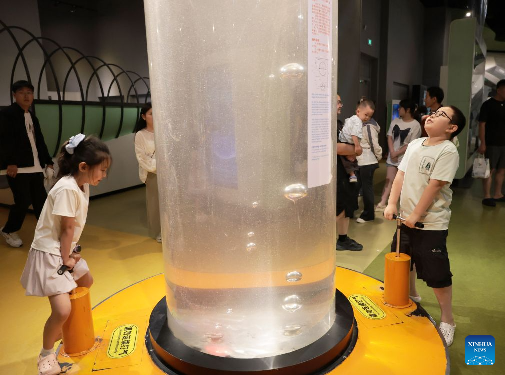 Pelawat belajar tentang tekanan cecair melalui satu pameran di Muzium Sains dan Teknologi Liaoning di Shenyang, provinsi Liaoning, timur laut China, 19 Julai 2026. (Xinhua/Li Gang)