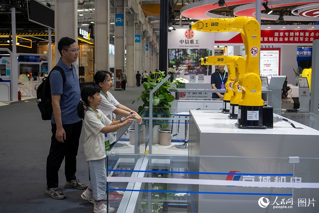 Kanak-kanak melihat robot yang dipamerkan pada Persidangan Robot Dunia 2026 di Beijing, 19 Ogos 2026. (People's Daily Online/Weng Qiyu)