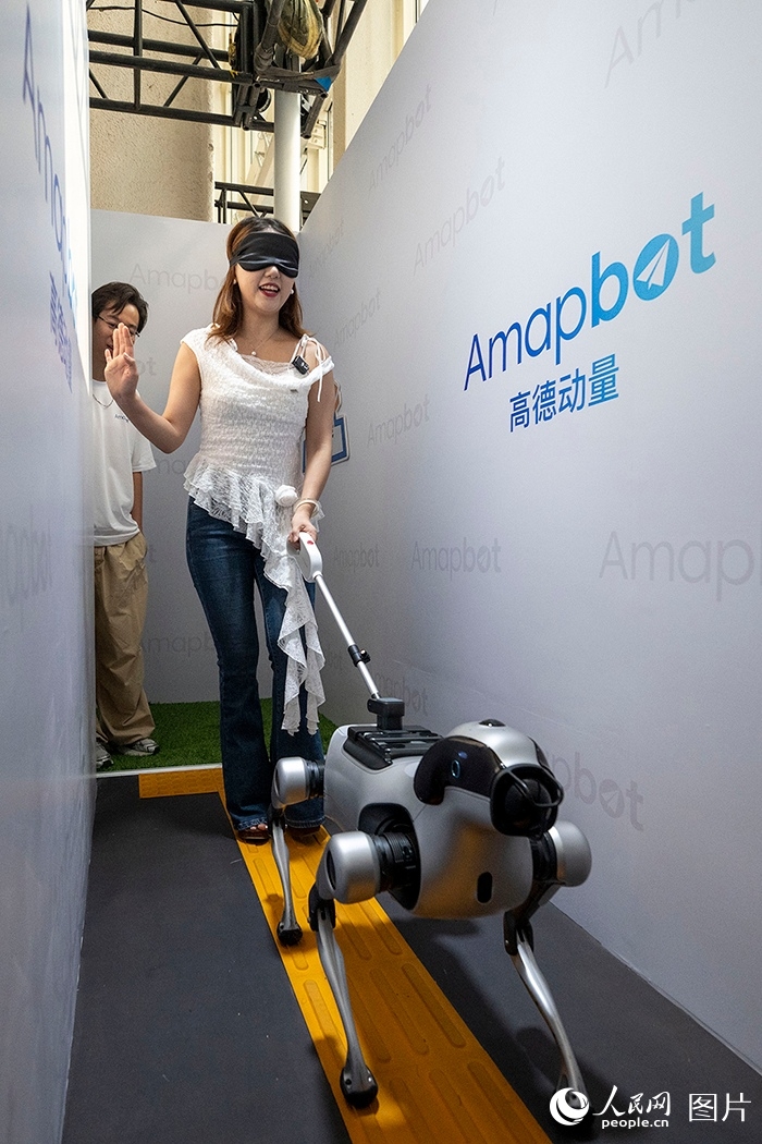 Seorang pelawat asing memerhatikan robot manusia dari dekat pada Persidangan Robot Dunia 2026 di Beijing, 19 Ogos 2026. (People's Daily Online/Weng Qiyu)