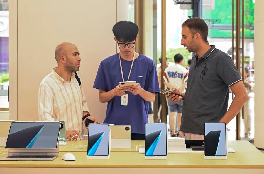 Pelancong asing membelek produk di sebuah kedai Huawei di Jalan Nanjing, Shanghai, timur China, 28 Julai 2026. (Xinhua/Chen Haoming)