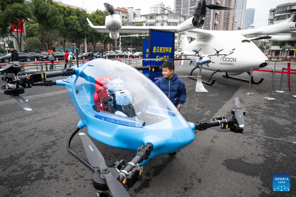 Seorang kanak-kanak melihat sebuah kenderaan berlepas dan mendarat menegak elektrik (eVTOL) di Wuhan, provinsi Hubei, tengah China, 24 Februari 2026. (Xinhua/Xiao Yijiu)