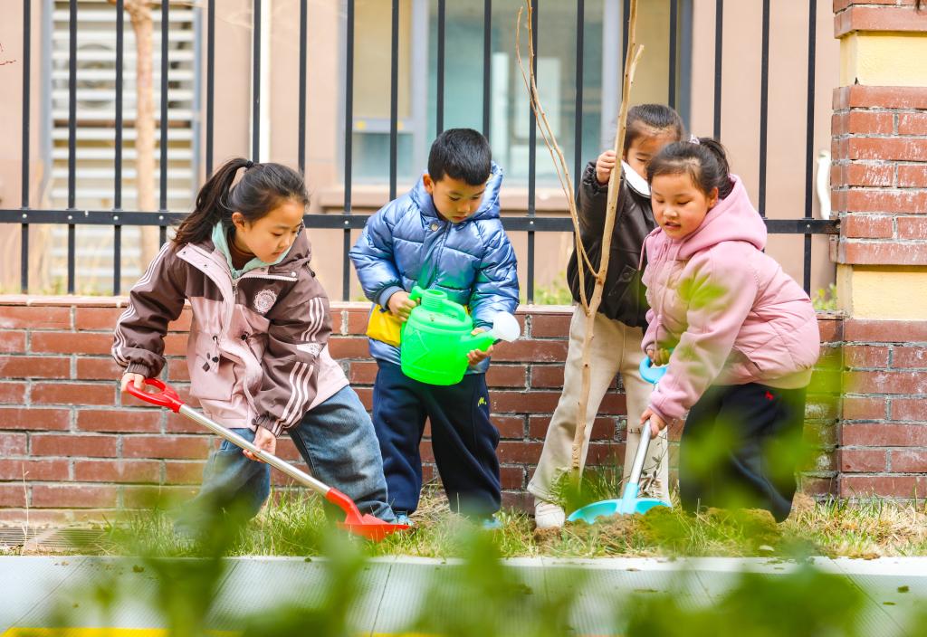 Kanak-kanak mengambil bahagian dalam acara menanam pokok di sebuah tadika di bandar Laoling, provinsi Shandong, timur China, 11 Mac 2026. (Foto oleh Jia Peng/Xinhua)