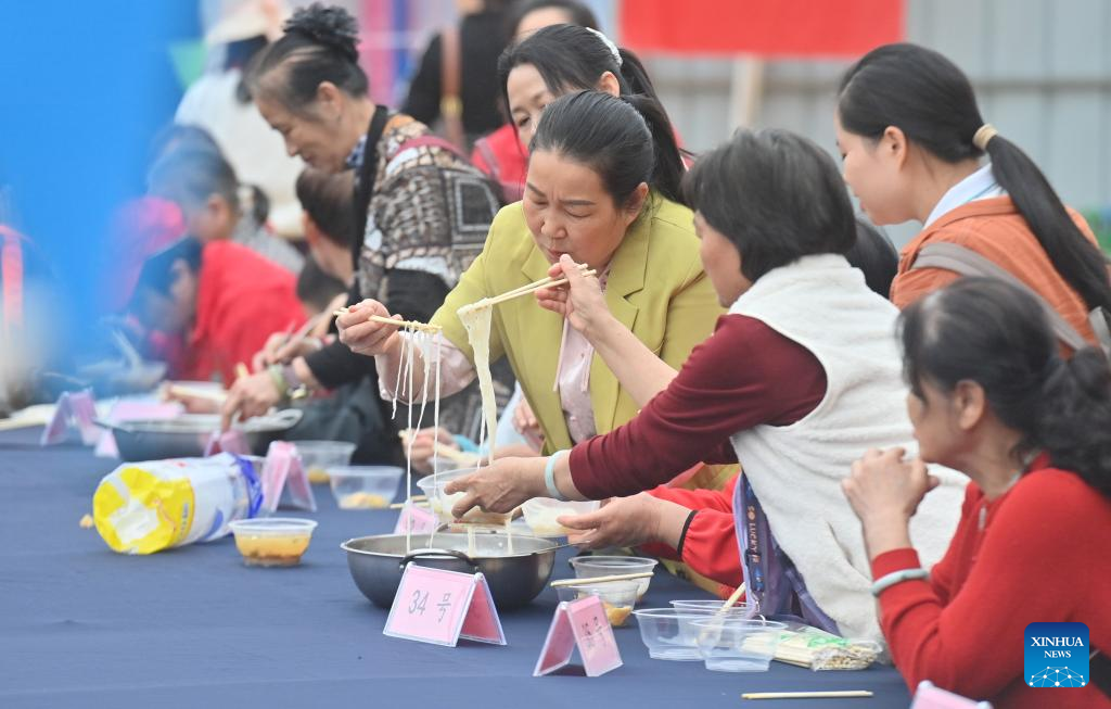 Orang ramai menjamah bihun Shengzha pada satu pertandingan ketukangan warisan budaya tak ketara di kaunti autonomi Yao Dahua, bandar Hechi, wilayah autonomi Zhuang Guangxi, selatan China, 21 Mac 2026.