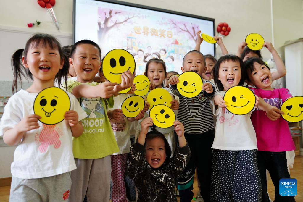 Kanak-kanak memegang ikon muka senyum sambil bermain di sebuah tadika di bandar Qinyang, provinsi Henan, tengah China, 7 Mei 2026. (Foto oleh Zhang Xinyu/Xinhua)