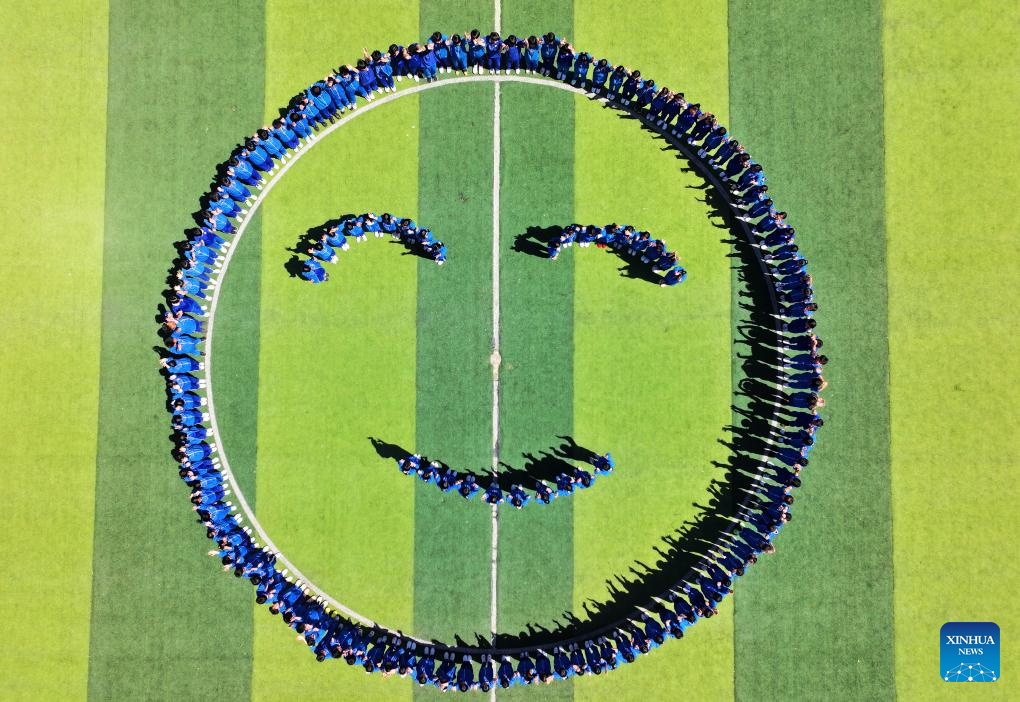 Foto dron pada 7 Mei 2026 menunjukkan para pelajar berkumpul untuk membentuk corak muka senyum di padang sebuah sekolah menengah di bandar Handan, provinsi Hebei, utara China. (Foto oleh Hao Qunying/Xinhua)