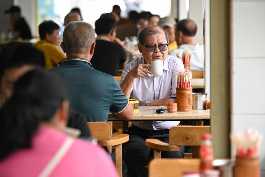 Orang menikmati Laobacha, tradisi penduduk Hainan berkumpul untuk menikmati teh dan snek sambil berbual-buat santai, di sebuah kedai di Wenchang, provinsi Hainan, selatan China, 17 Mei 2026. (Xinhua/Pu Xiaoxu)