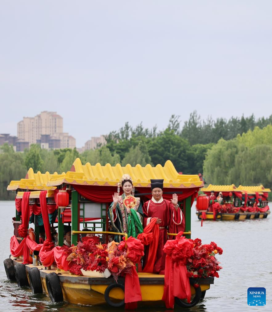 Pengantin baru bersiar-siar menaiki bot pada satu majlis perkahwinan berkumpulan di daerah Jizhou, Tianjin, utara China, 20 Mei 2026. (Xinhua/Li Ran)