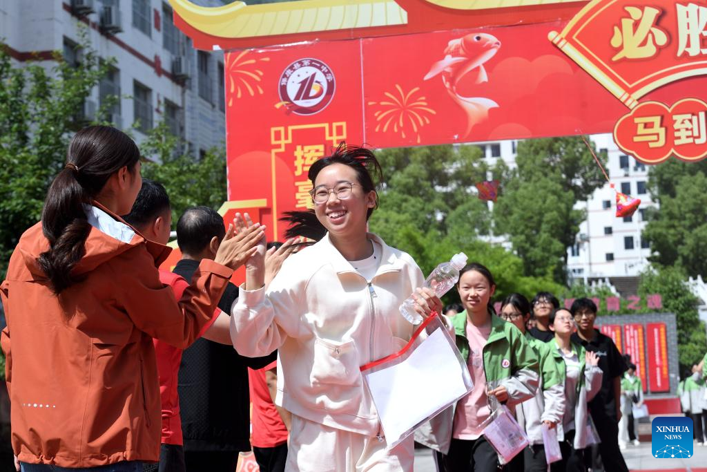 Seorang pelajar bertepuk ria dengan guru selepas peperiksaan kemasukan universiti awam di Xiangyang, provinsi Hubei, tengah China, 9 Jun 2026. (Foto oleh Yang Tao/Xinhua)