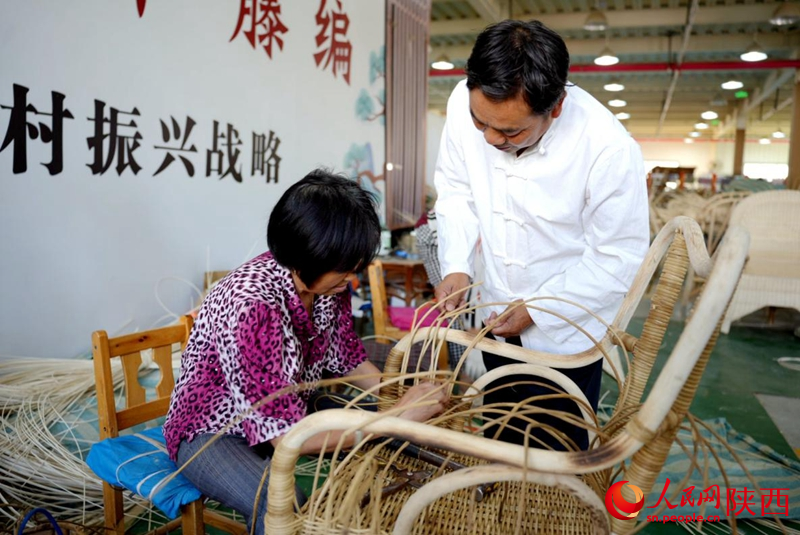 Chen Liangshun (kanan), seorang wakil pewaris kraf anyaman rotan di Hanzhong, Provinsi Shaanxi, barat laut China, sedang memberi arah kepada seorang pekerja terhadap teknik anyaman rotan tradisional. (People’s Daily Online/Zou Xing)
