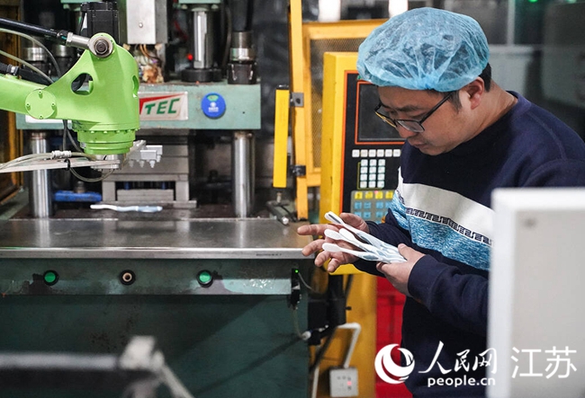 Seorang juruteknik memeriksa keberkesanan suntikan mesin di sebuah barisan pengeluaran di sebuah kilang berus gigi di pekan Hangji, bandar Yangzhou, Provinsi Jiangsu di timur China. (People’s Daily Online/Gao Chao)