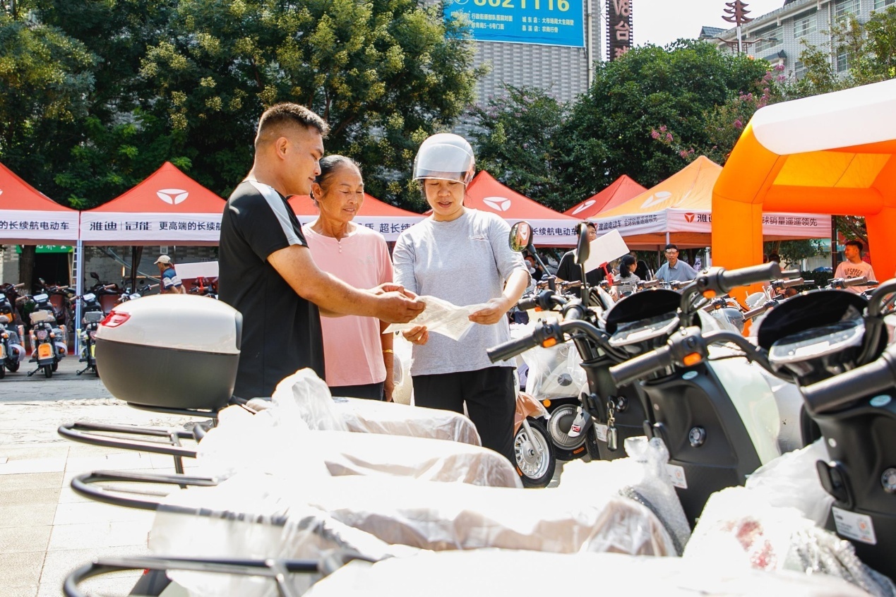 Seorang wanita membeli skuter elektrik di perbandaran Shuangjiang, kaunti autonomi Tongdao Dong, Huaihua, Provinsi Hunan, tengah China. (Foto oleh Hu Xianbing)