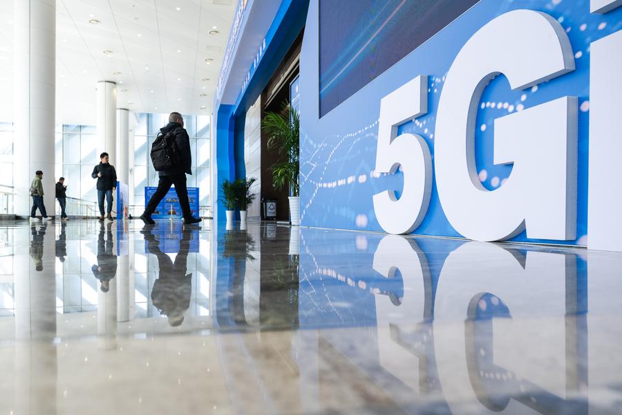 Pelawat berjalan masuk ke arah venue Persidangan Internet Industri + 5G China 2025 di Wuhan, Provinsi Hubei, tengah China pada 21 November 2025. (Xinhua/Xiao Yijiu)