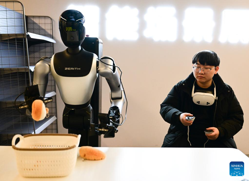Seorang kakitangan melatih robot manusia mengambil objek untuk tujuan pengumpulan data di syarikat robotik Zerith, di Hefei, provinsi Anhui, timur China, 25 November 2025. (Xinhua/Zhou Mu)