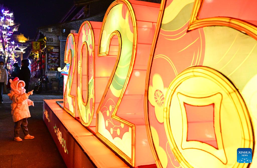 Seorang kanak-kanak melihat set tanglung di kawasan berpemandangan indah kota purba kaunti Huangyuan, Xining, provinsi Qinghai, barat laut China, 2 Januari 2026. (Xinhua/Qi Zhiyue)