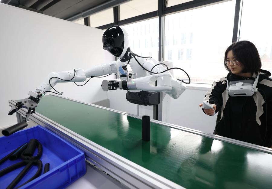 Seorang kakitangan melatih robot di pusat inovasi latihan persepsi digital taktil dan multimod kecerdasan terkandung di daerah Shijingshan, Beijing, ibu kota China, 17 Mac 2026. (Xinhua/Zhang Chenlin)