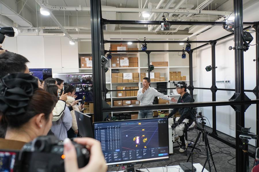 Li Yao (kedua dari kanan, belakang) Naib Presiden dan Rakan Kongsi Noitom Technology Co., Ltd. memperkenalkan koleksi data tingkah laku manusia dan robot kejituan tinggi di sebuah taman perindustrian inovasi kecerdasan terkandung di Zhongguancun, daerah Haidian, Beijing, ibu kota China, 18 Mac 2026. (Xinhua/Xie Han)