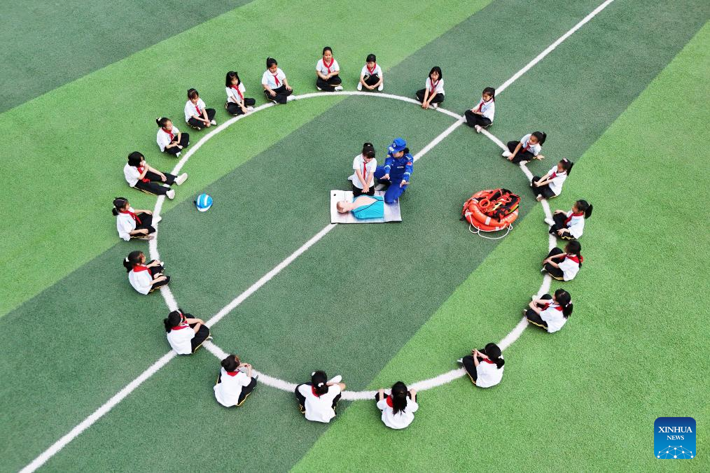 Foto dron pada 11 Mei 2026 menunjukkan seorang anggota Pasukan Penyelamat Blue Sky mendemonstrasikan teknik resusitasi kardiopulmonari (CPR) di sebuah sekolah rendah di Tangshan, provinsi Hebei, utara China. (Zhu Dayong/Xinhua)