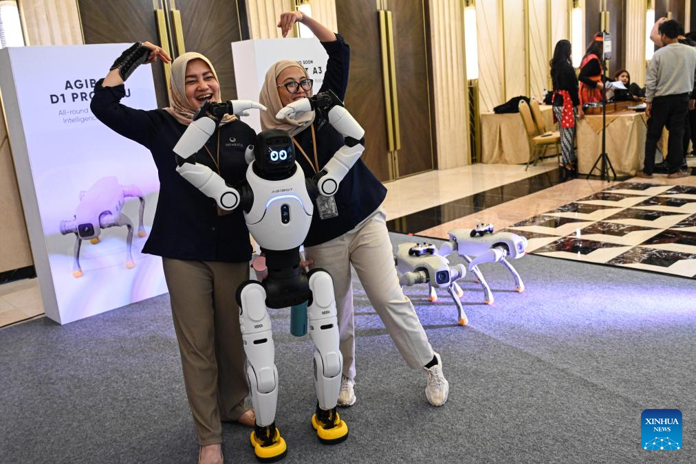 Tetamu berinteraksi dengan sebuah robot manusia pada satu persidangan rakan kongsi oleh syarikat China AGIBOT di Jakarta, Indonesia, 9 Jun 2026. (Xinhua/Agung Kuncahya B.)