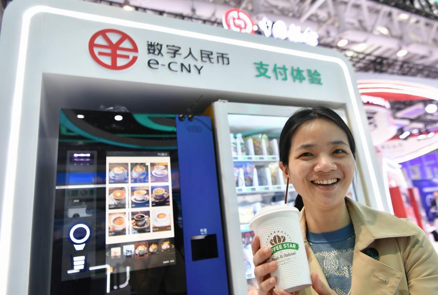 Seorang pelawat menunjukkan secawan kopi yang dibeli dengan yuan digital atau e-CNY, pada pameran sempena Sidang Kemuncak China Digital ke-6 di Fuzhou, provinsi Fujian, timur China, 26 April 2023. (Xinhua/Wei Peiquan)
