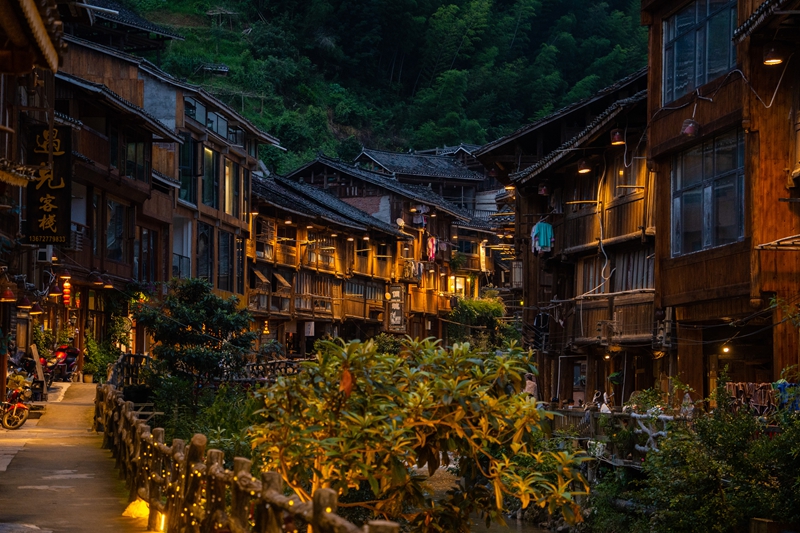 Selepas tenggelamnya matahari, cahaya lampu menerangi kampung Dong Zhaoxing di kaunti Liping, kawasan autonomi Miao dan Dong Qiandongnan, provinsi Guizhou, barat daya China. (People's Daily Online/Yang Qian)