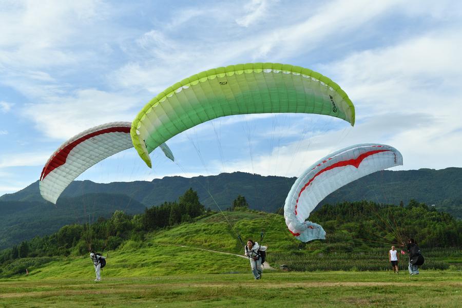 Foto dron bertarikh 30 Julai 2026 ini menunjukkan pelancong meluncur layar bersama peluncur profesional di sebuah pangkalan di pekan Jiuzhou, kaunti Huangping, provinsi Guizhou, barat daya China. (Xinhua/Yang Wenbin)