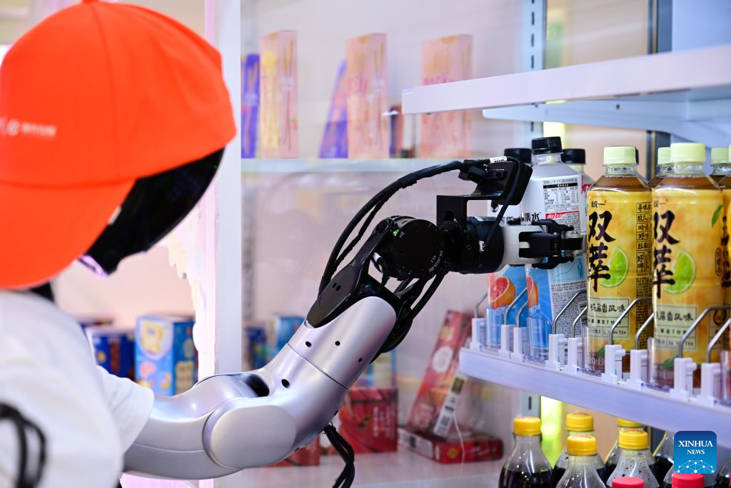 Sebuah robot mengambil sebotol minuman elektrolit dari rak di sebuah kedai robot pintar terkandung di Jalan Leijie, Hefei, provinsi Anhui, timur China, 26 Ogos 2026. (Xinhua/Zhou Mu)