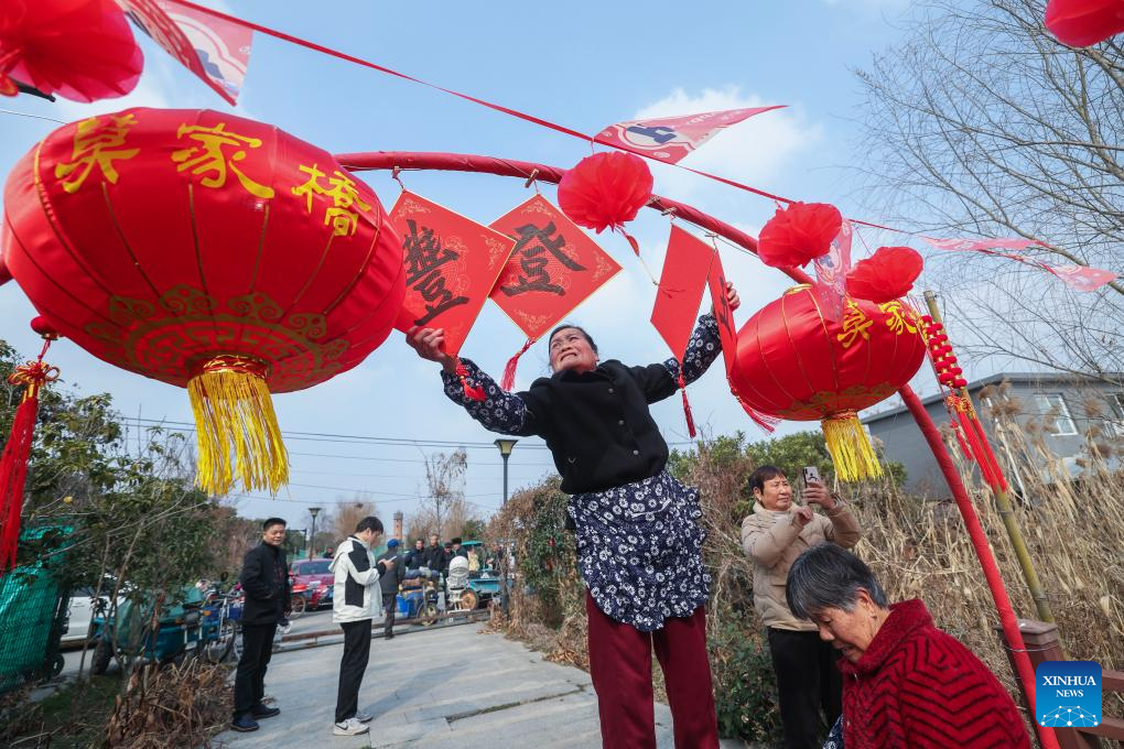 Seorang penduduk memasang tanglung dan hiasan perayaan di kampung Mojiaqiao, Hangzhou, provinsi Zhejiang, timur China, 2 Februari 2026. (Xinhua/Xu Yu)