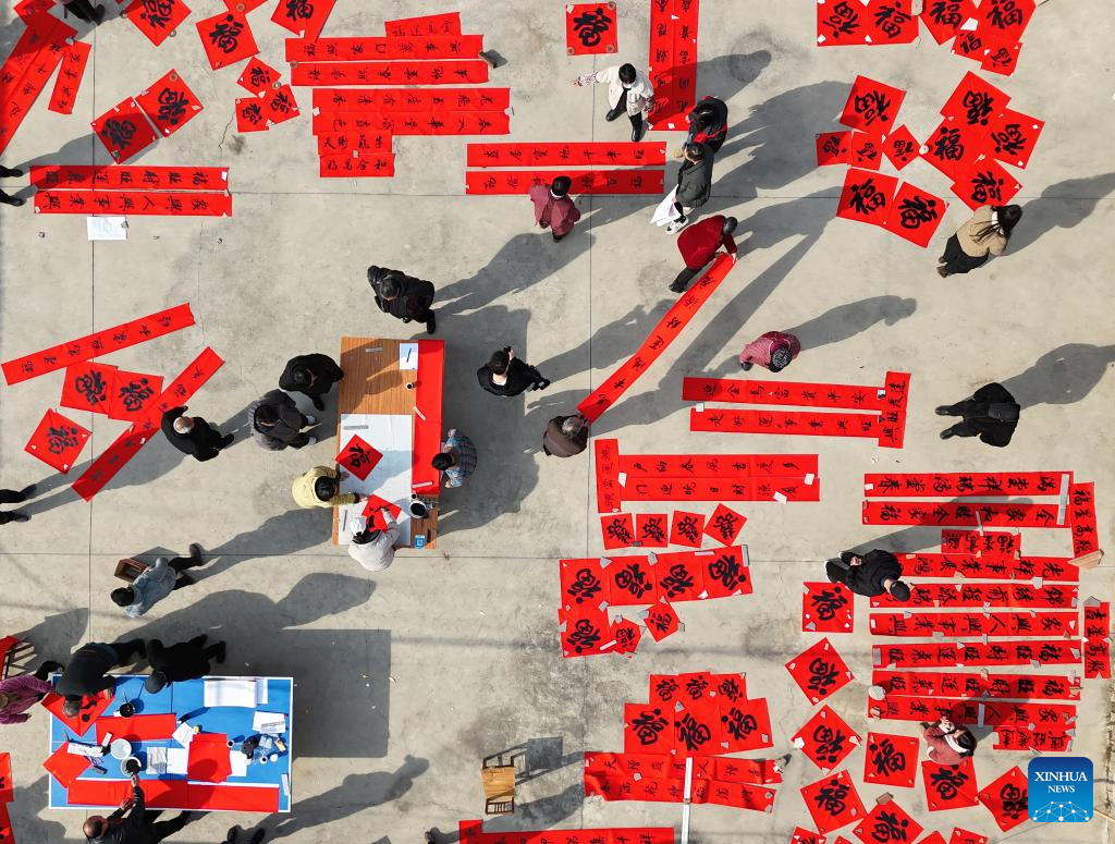 Foto dron bertarikh 5 Februari 2026 menunjukkan seorang jurukhat menulis kuplet dan karakter “Fu” (tuah) untuk penduduk di kampung Houcuizhuang, pekan Huangzhuang, kaunti Wenxian, bandar Jiaozuo, provinsi Henan, tengah China. (Huang Fuxing/Xinhua)