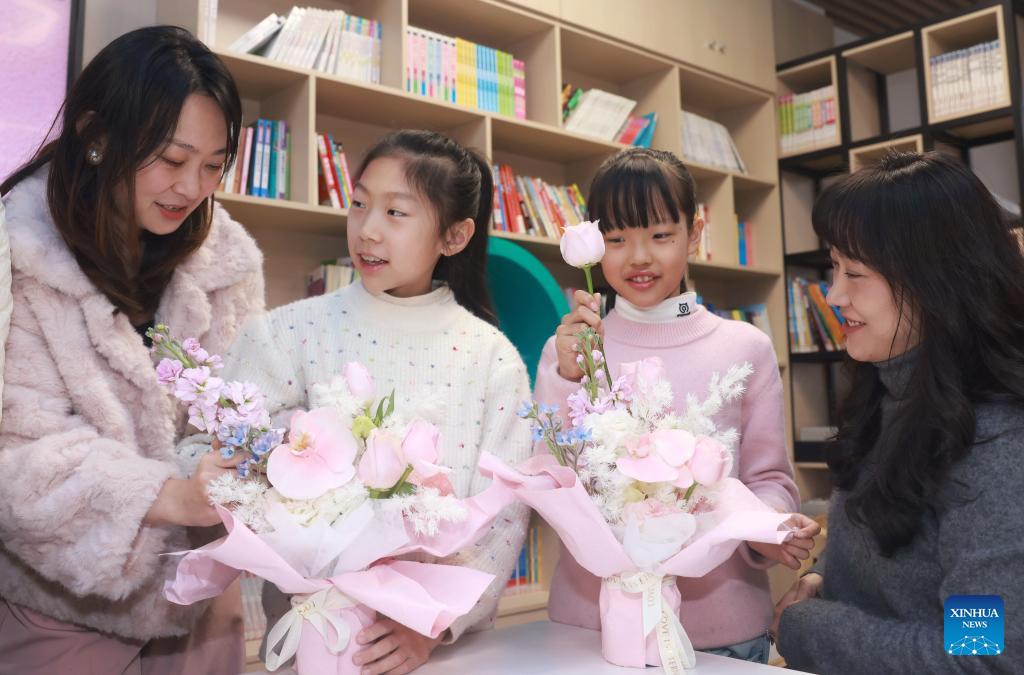 Murid-murid belajar menggubah bunga bersama ibu mereka di sebuah sekolah rendah di daerah Hongshan, Wuhan, provinsi Hubei, tengah China, 8 Mac 2026. (Foto oleh Zhao Jun/Xinhua)