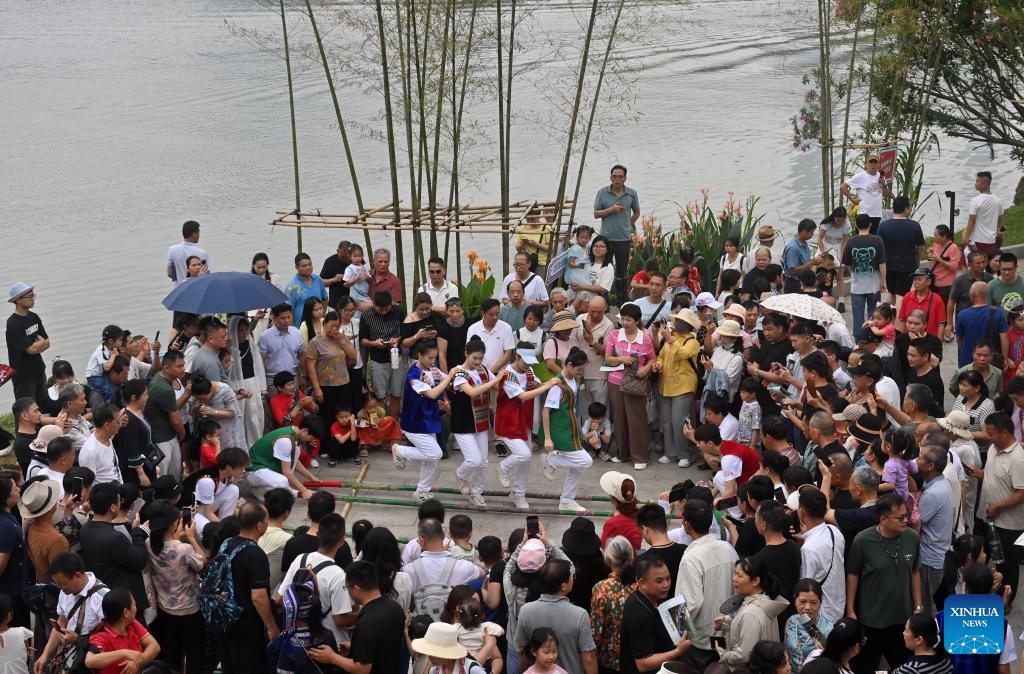 Orang ramai menonton persembahan tarian rakyat pada satu acara sambutan Pesta Sanyuesan di Nanning, wilayah autonomi Zhuang Guangxi, selatan China, 19 April 2026.