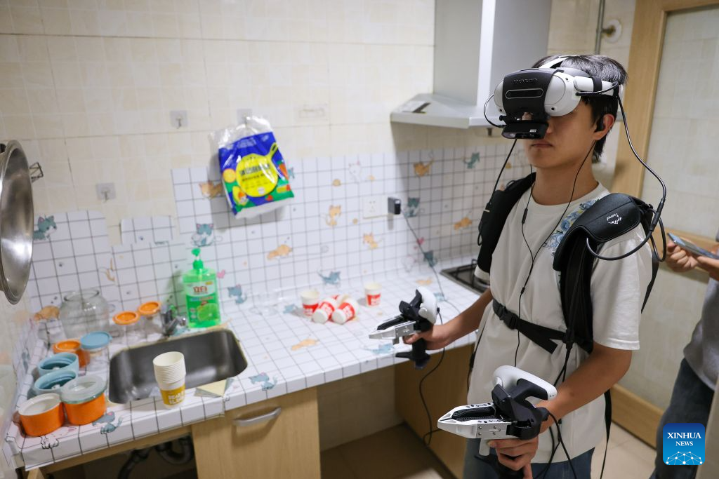 Seorang pengumpul data mengutip input dunia nyata untuk alat pintar terkandung dalam senario dapur di daerah Nanming, bandar Guiyang, provinsi Guizhou, barat daya China, 6 Julai 2026. (Xinhua/Liu Xu)